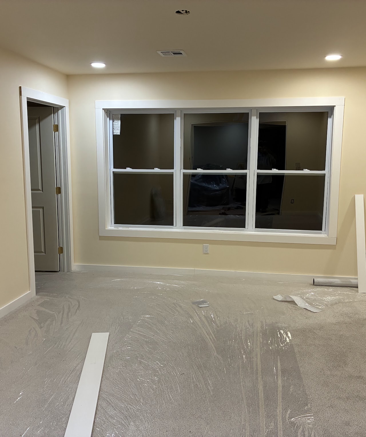 A freshly finished room with a wide window and protected floor