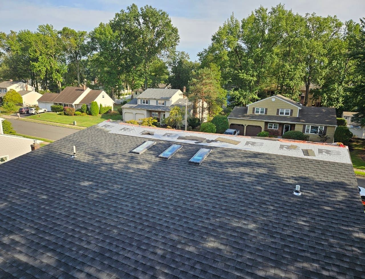 A new asphalt shingle roof seen from above with two skylights